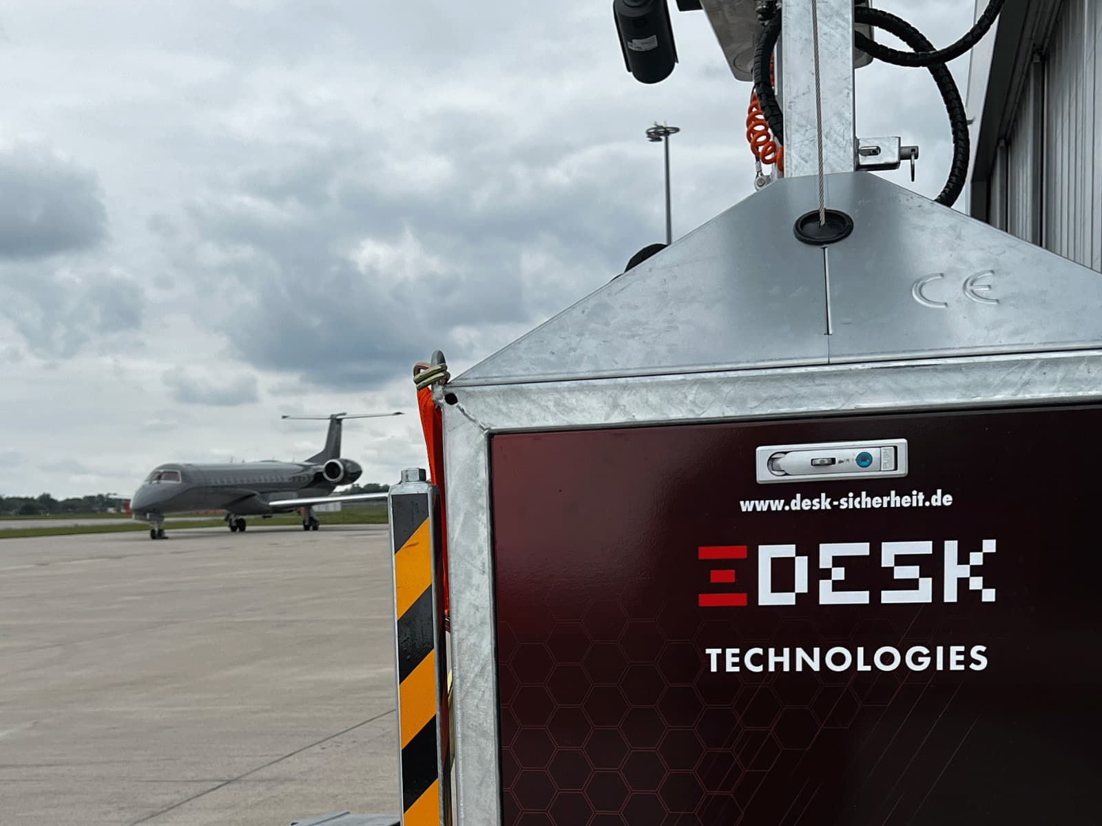 Mobiles Drohnenabwehrsystem von DESK Technologies mit Sensormast am Flughafenvorfeld vor Privatjet